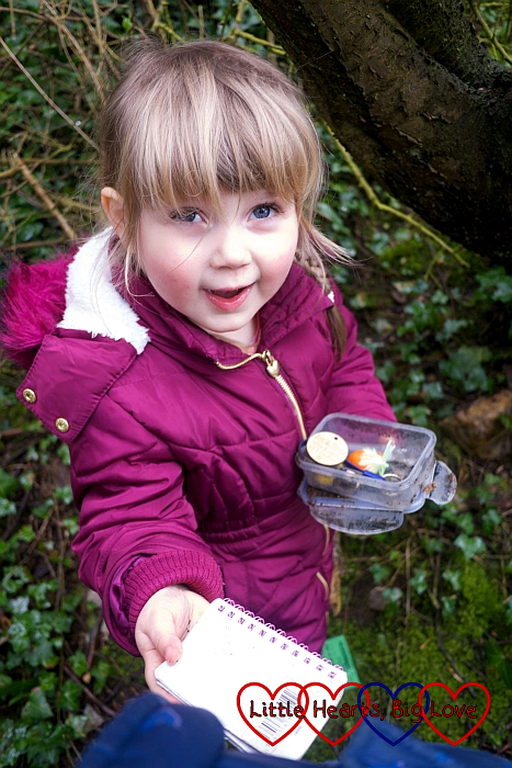Sophie holding a geocache with swaps in the box