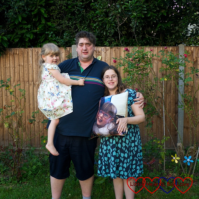 Me, hubby and Sophie in the garden holding the cushion with Jessica's picture on