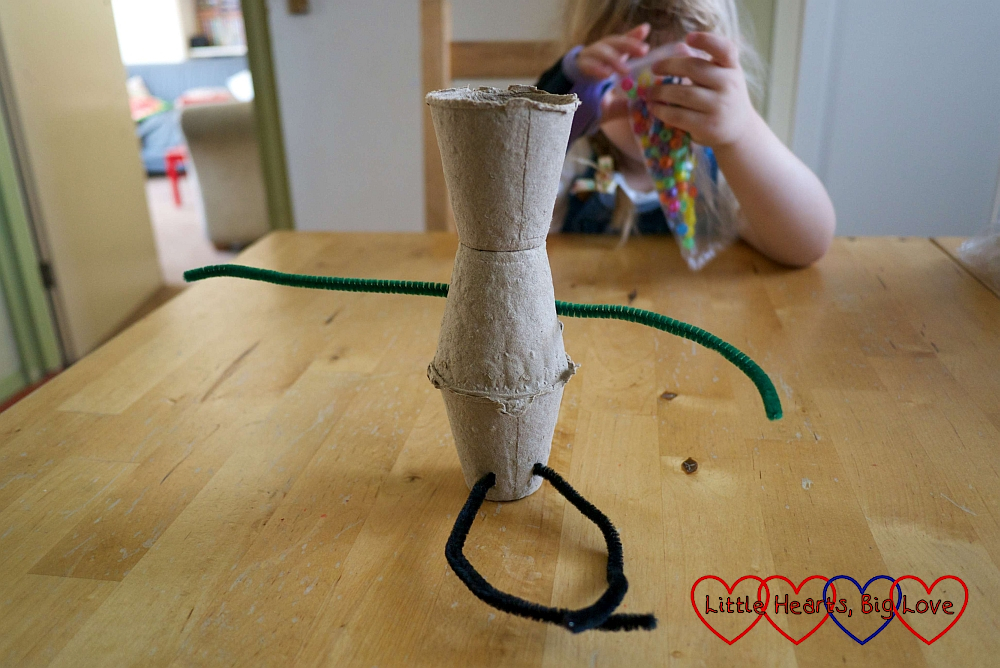 The three pots with two pipe cleaners threaded through to form arms and legs