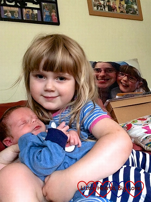 Sophie cuddling baby Thomas with Jessica's photo cushion in the background