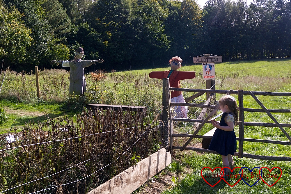 Sophie standing next to some scarecrows in the allotment area