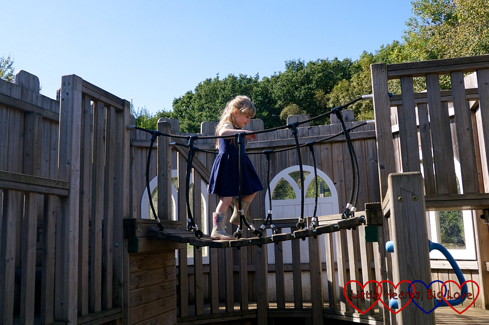 Sophie running across a rope bridge in the playground at Chiltern Open Air Museum