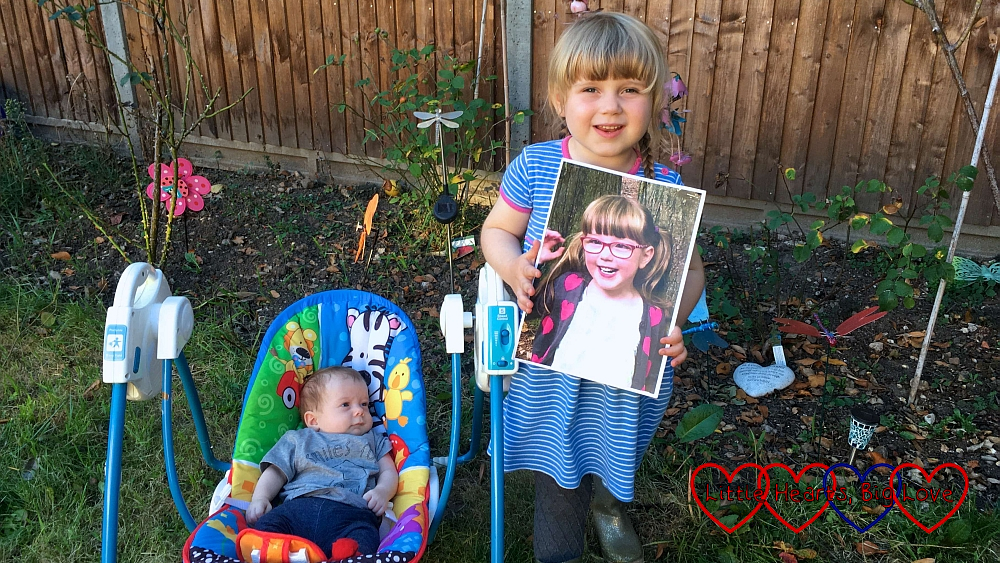 Sophie and Thomas in the garden with a picture of Jessica