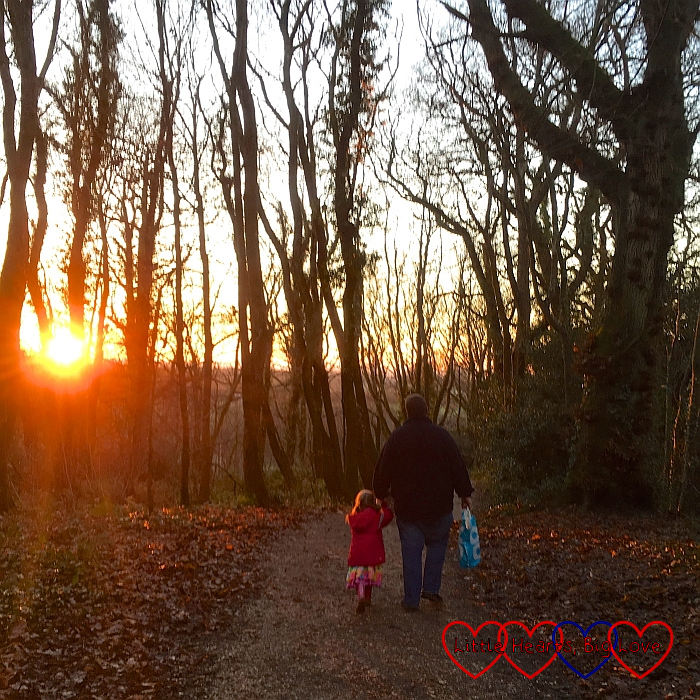 Sophie and Daddy walking through the woods towards the setting sun
