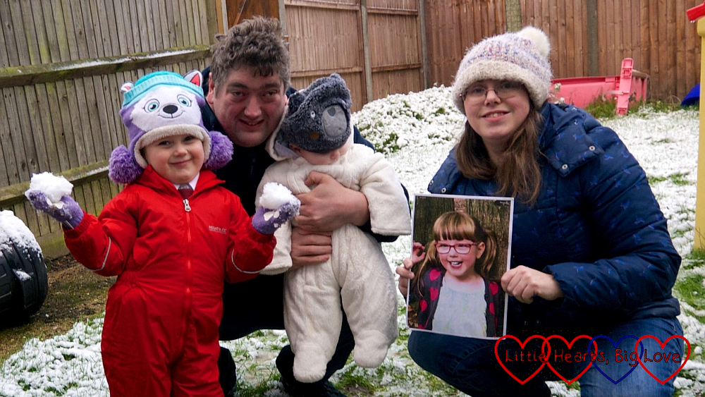 Sophie, hubby, Thomas and me holding a picture of Jessica next to the snowman Sophie built