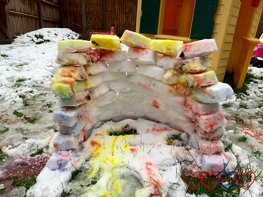 A nine-layer high semi-circle of snowbricks with coloured ones at the front and on top