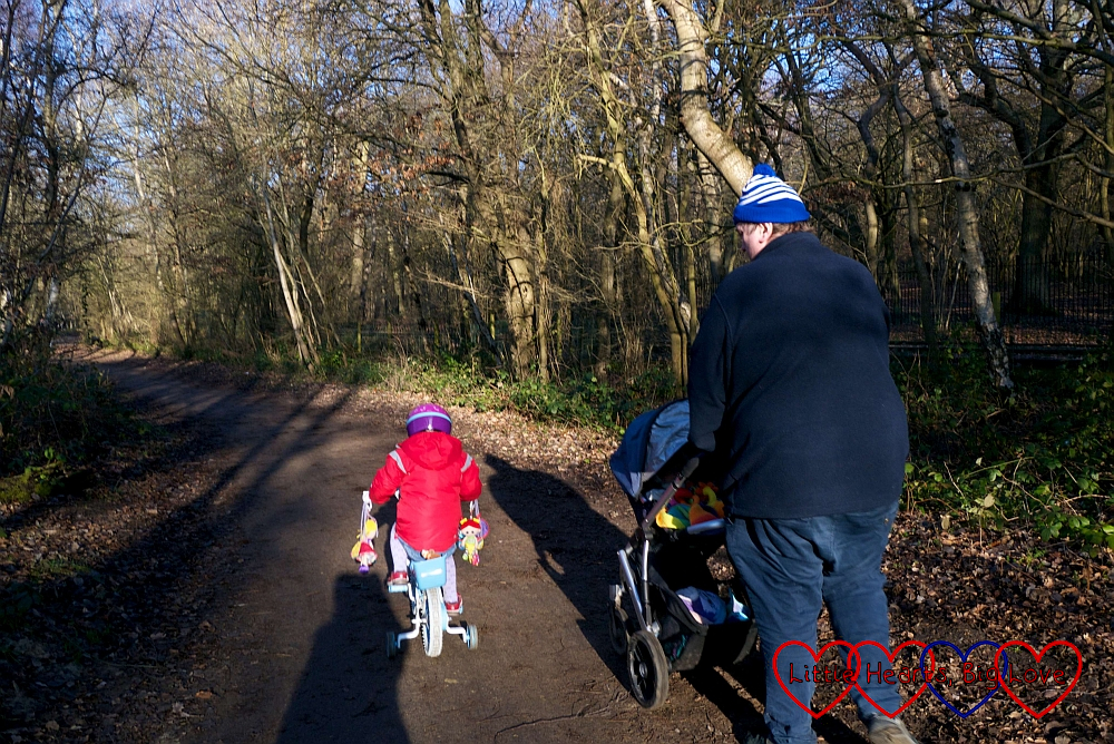 Sophie cycling along the path; Daddy following with Thomas in the buggy