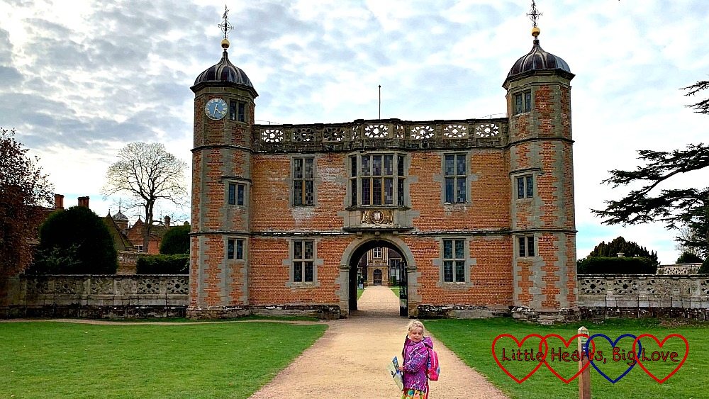 Sophie standing in front of the gate house at Charlecote Park