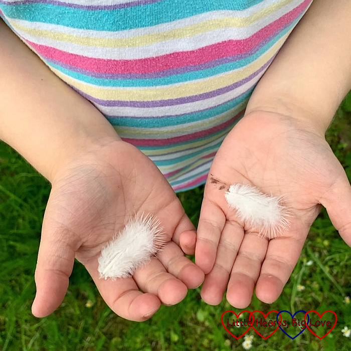 Sophie holding two white feathers