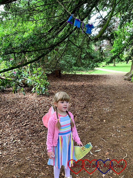 Sophie looking up at the elves' washing in the trees with her activity sheet