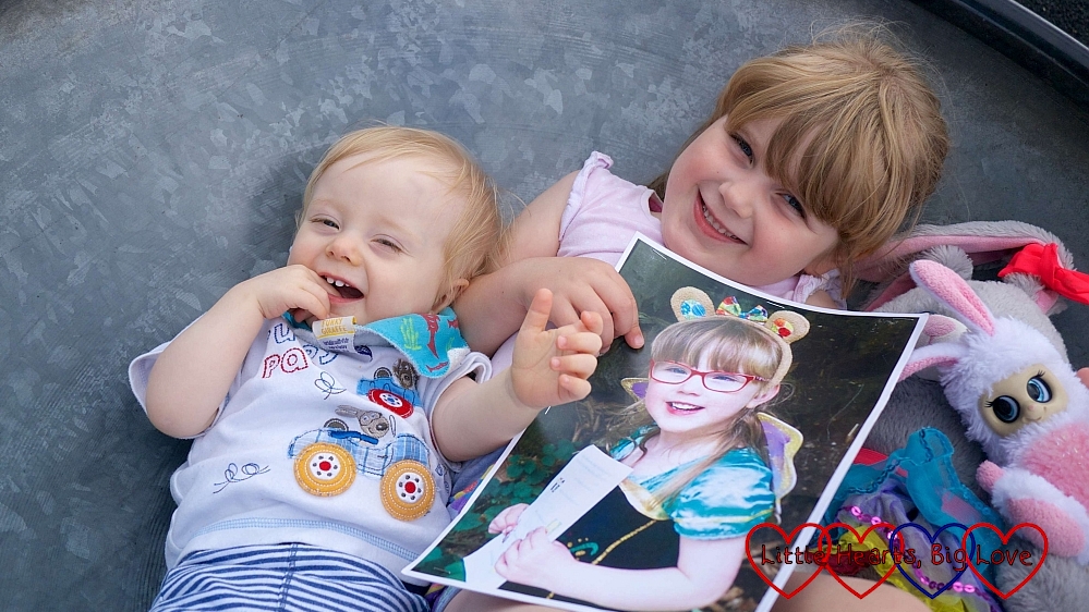 Thomas and Sophie holding a picture of Jessica in a spinning saucer