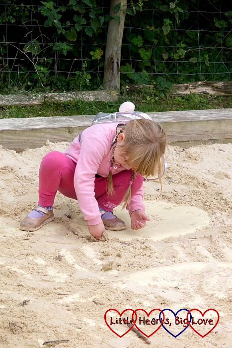 Sophie digging in the sand pit to uncover some dinosaur bones
