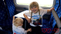 Sophie and Thomas (wearing their JoGLE for Jessica T-shirts) on the train to Wick