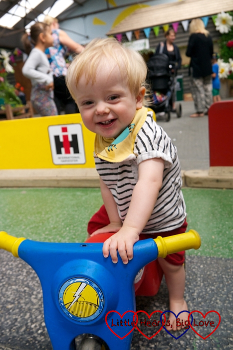 Thomas standing against a ride-on bike
