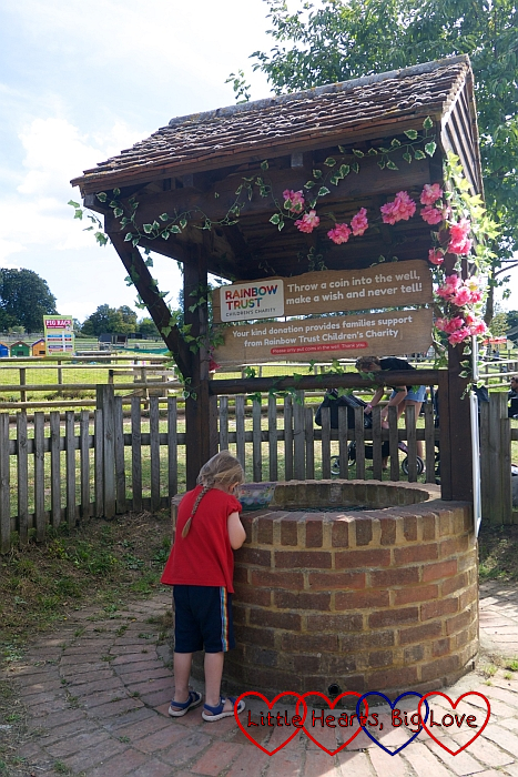 Sophie putting a coin in the wishing well