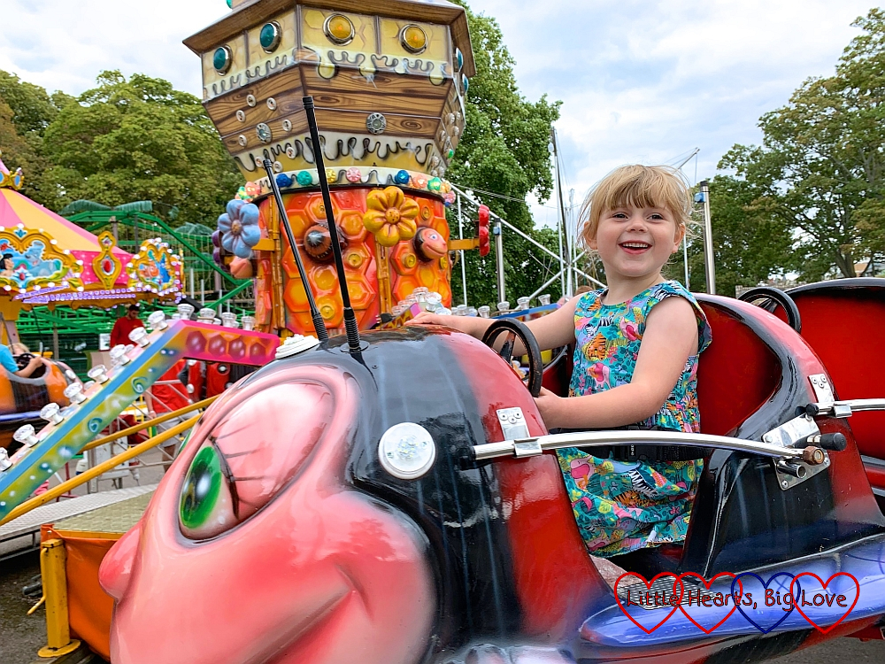 Sophie on a red bumblebee ride at the fun fair