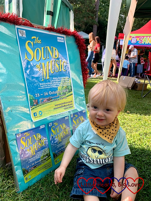 Thomas in front of a board covered in The Sound of Music posters and flyers