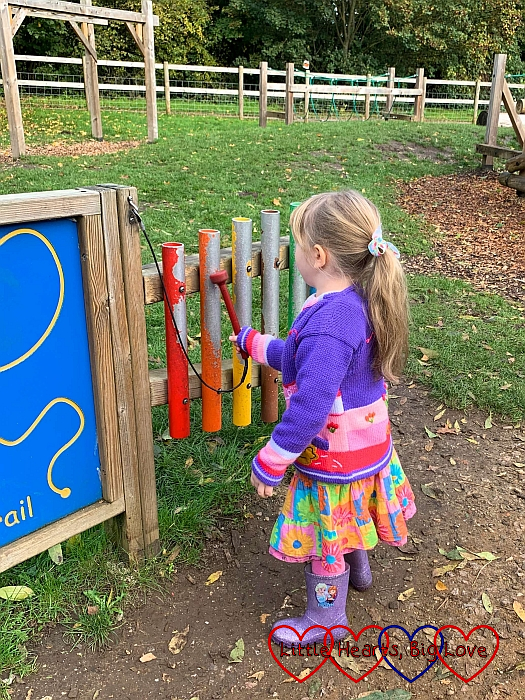 Sophie playing do-re-mi on the musical bars in the playground