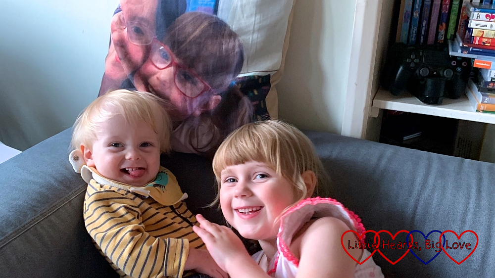 Thomas and Sophie cuddling on the sofa in front of Jessica's photo cushion