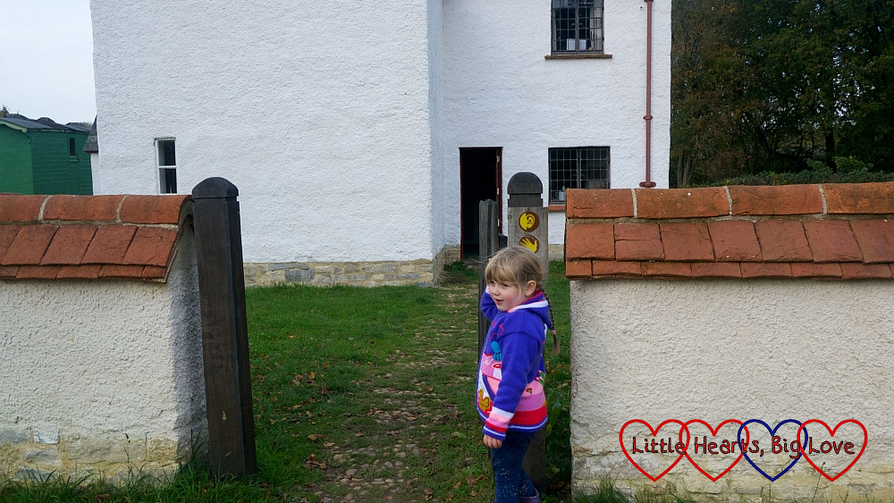 Sophie looking at the ‘listen’ and ‘feel’ signs outside the Haddenham Croft Cottage