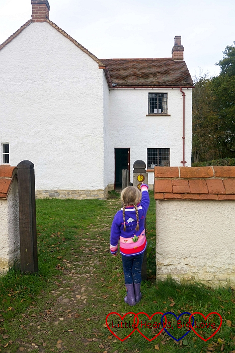 Sophie looking at the ‘listen’ and ‘feel’ signs outside the Haddenham Croft Cottage