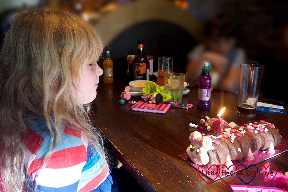 Sophie blowing out the candle on her Connie the Caterpillar birthday cake