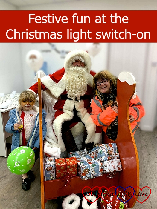 Sophie with her face painted like a reindeer and Auntie Maxine standing either side of Father Christmas in his sleigh - "Festive fun at the Christmas light switch-on"