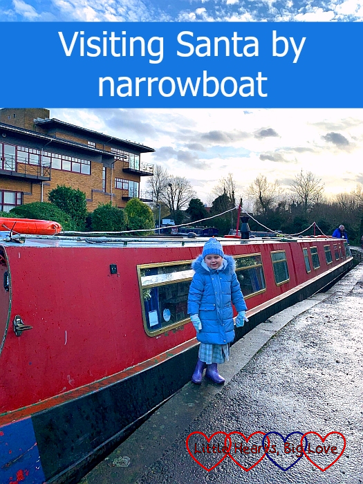 Sophie standing in front of a red narrowboat - "Visiting Santa by narrowboat"