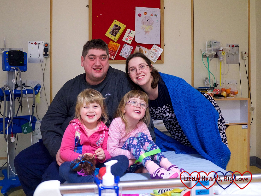 Hubby, me, Sophie and Jessica sitting on Jessica's hospital bed in December 2017