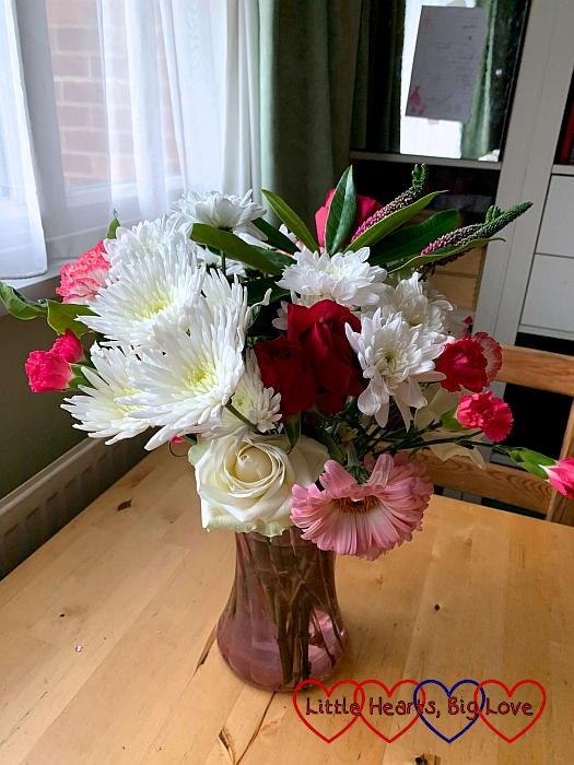 A bouquet of white and pink flowers including roses, carnations and gerbera daisies