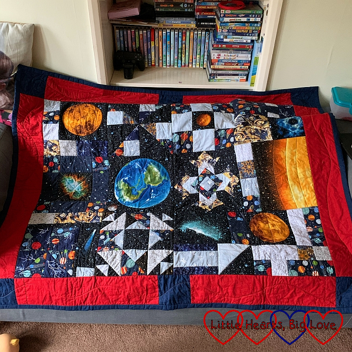 Thomas's space themed quilt with planets and stars on it