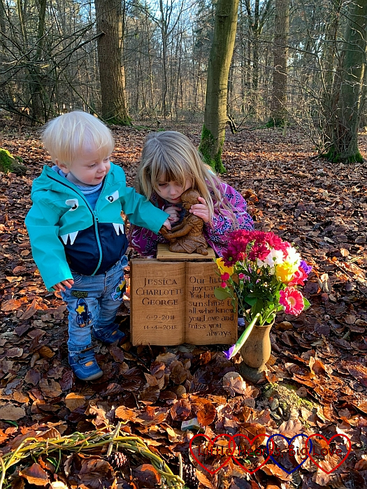 Thomas and Sophie holding and looking at the carving of Jessica on her memorial at her forever bed