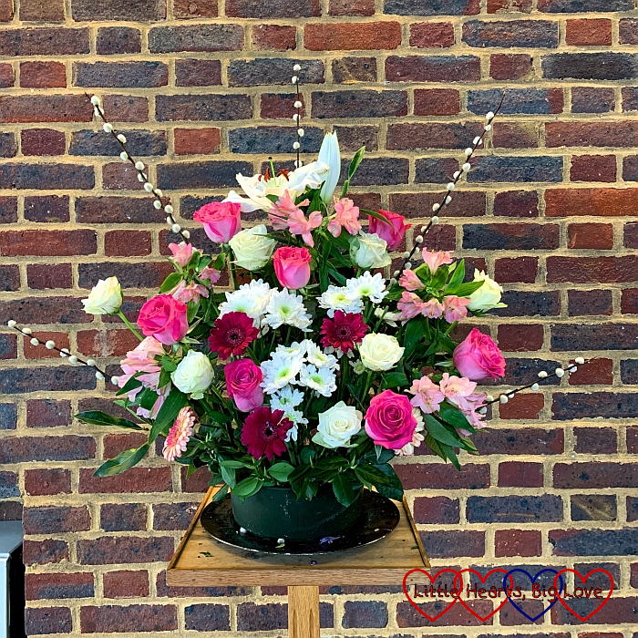 A flower arrangement with pink and white roses, gerberas, crysanthemums and pussy willow