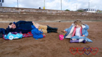 Hubby lying on the picnic blanket while Thomas and Sophie play in the sand on the beach