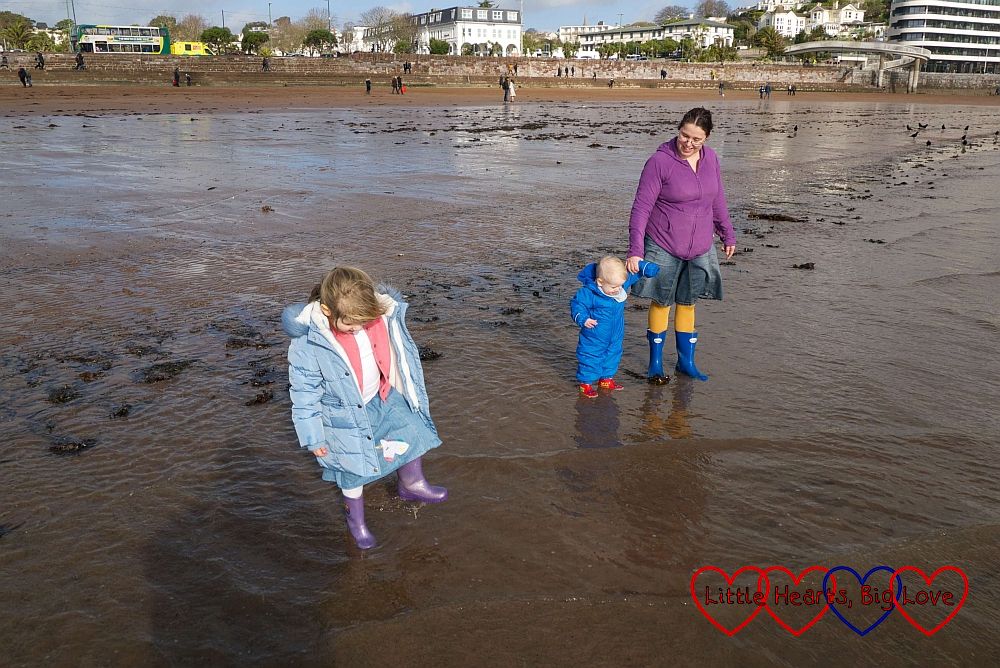Me holding Thomas’s hand with Sophie next to us, paddling in the sea at Torquay in our wellies