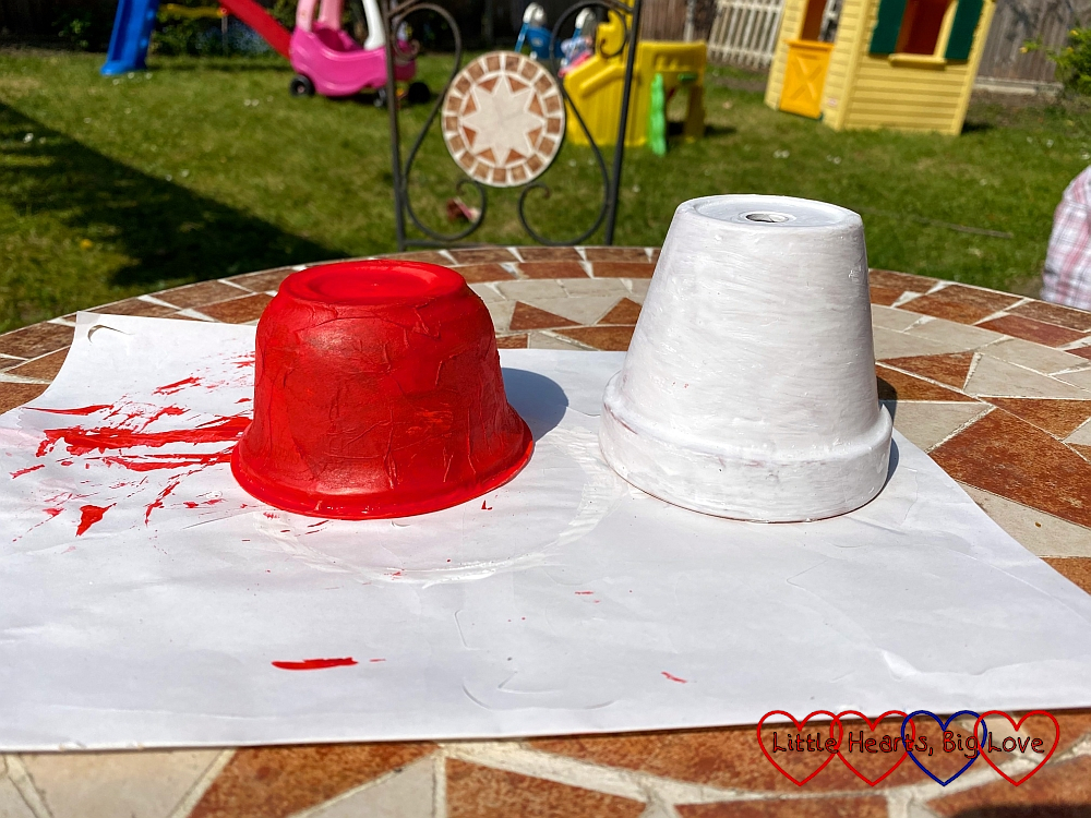A yogurt pot painted red and a plant pot painted white