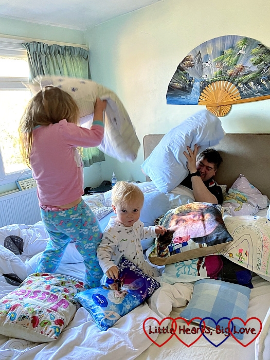 Sophie, and Daddy having a pillow fight with Thomas sitting between them