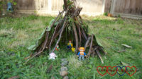 A toy den made of sticks with Playmobil 123 and Duplo figures inside