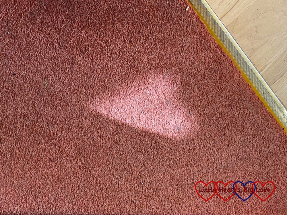 A heart-shaped patch of light on the carpet