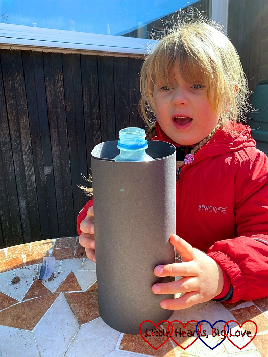 Sophie wrapping the plastic bottle in black card
