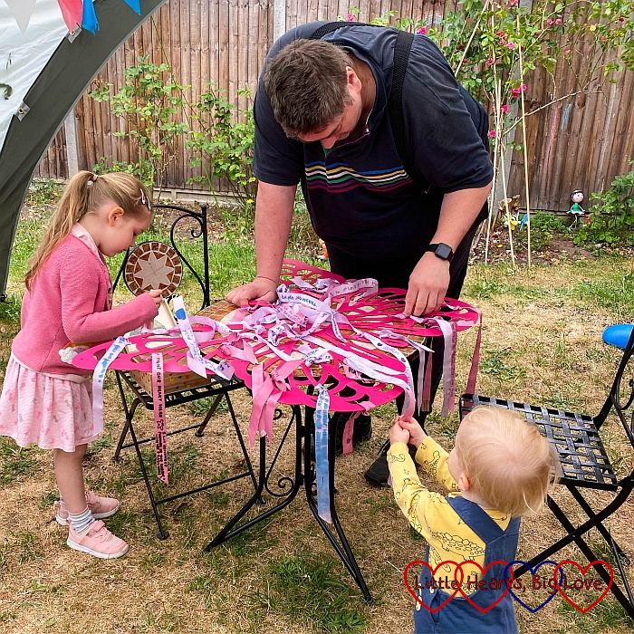 Sophie, Daddy and Thomas removing ribbons from Jessica's memorial butterfly