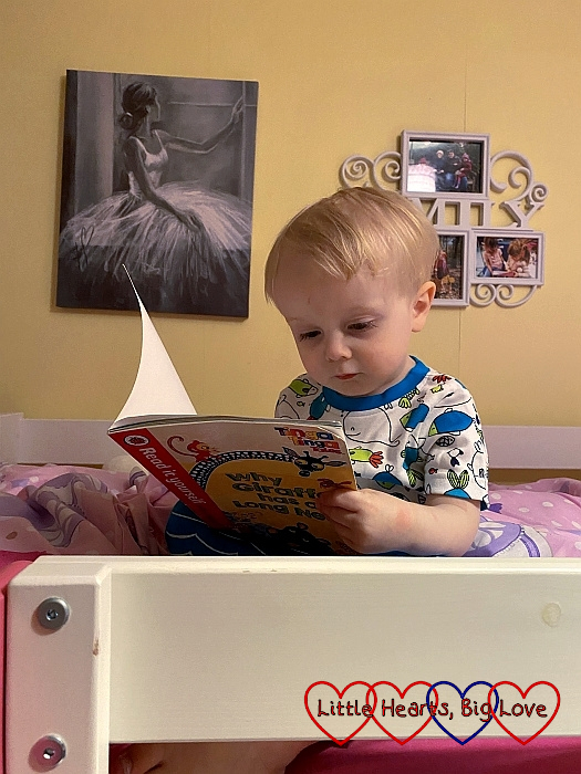 Thomas sitting on Sophie's bed looking at a book