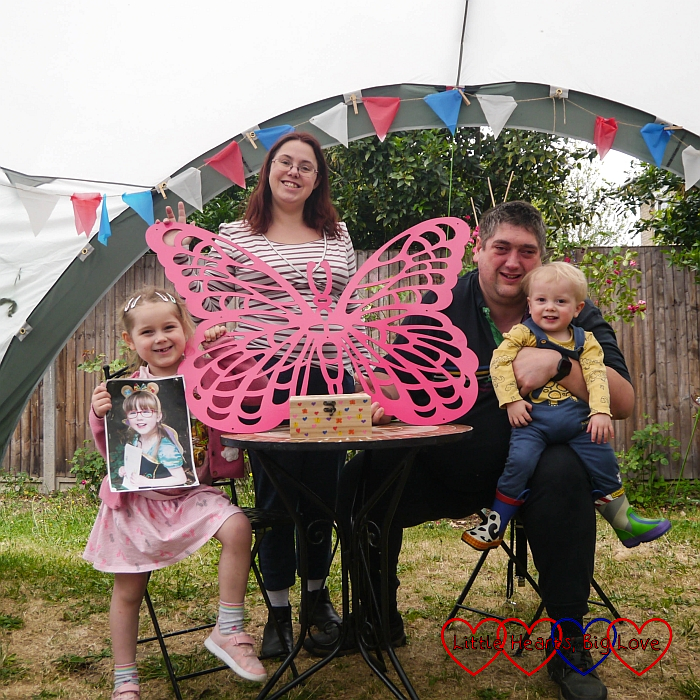 Sophie (holding a photo of Jessica), me (holding Jessica's memorial butterfly with her memory box on the table in front of it) and hubby holding Thomas, out in the garden