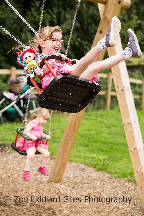 A very smiley Jessica on a swing with her Kerry doll