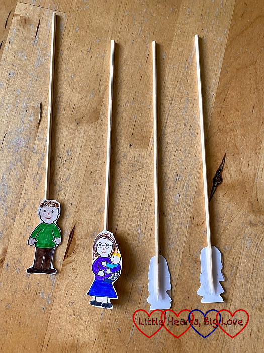 Characters cut from white card stuck to wooden sticks with sticky tape