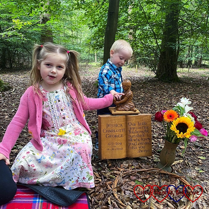 Sophie and Thomas with the wooden carving of Jessica at Jessica's forever bed
