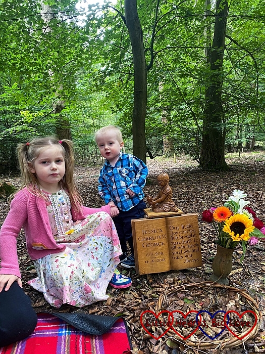 Sophie and Thomas with the wooden carving of Jessica at Jessica's forever bed