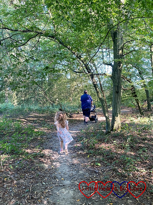 Sophie following behind Daddy pushing the buggy through Bayhurst Wood