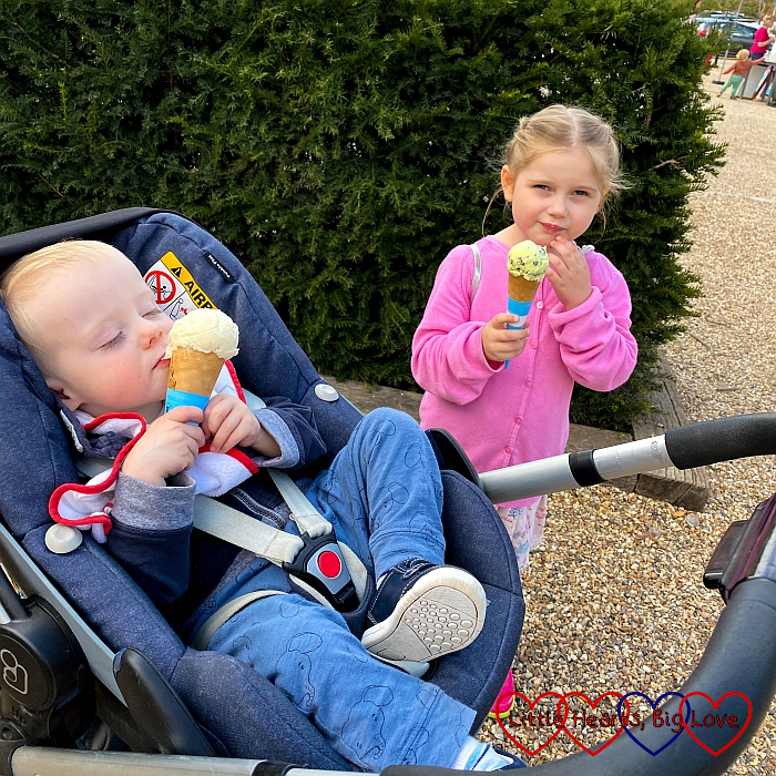 Thomas in his buggy and Sophie standing next to him both enjoying an ice-cream