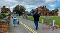 Sophie and Daddy walking along the main road in Datchet